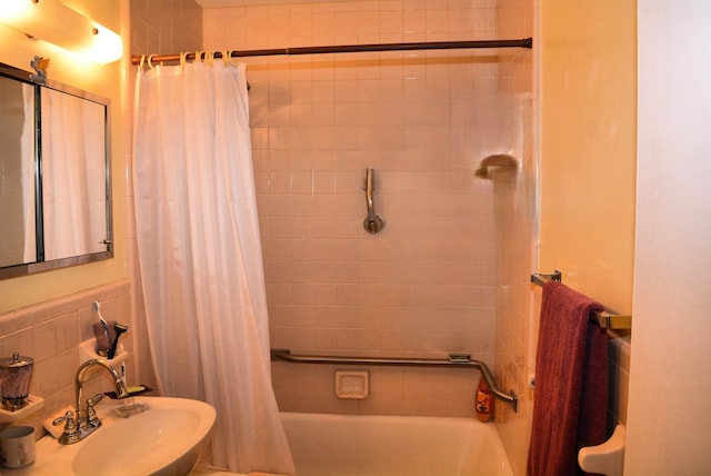 bathroom with shower / tub combo with curtain and a sink