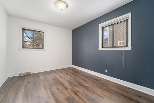empty room featuring wood finished floors and baseboards