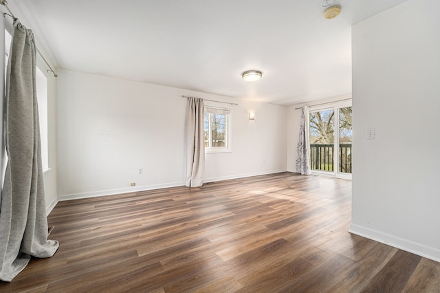 spare room featuring healthy amount of natural light, wood finished floors, and baseboards