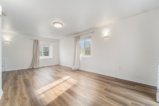 empty room featuring light wood-type flooring and baseboards