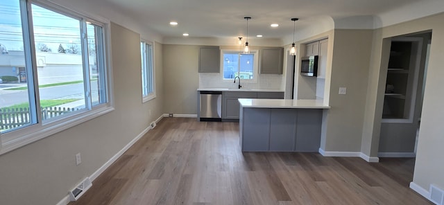 kitchen featuring visible vents, gray cabinetry, a sink, and appliances with stainless steel finishes