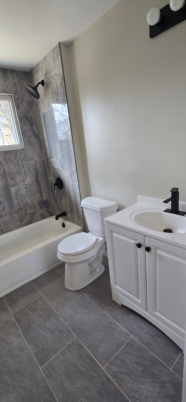 bathroom featuring toilet, tile patterned floors, vanity, and washtub / shower combination