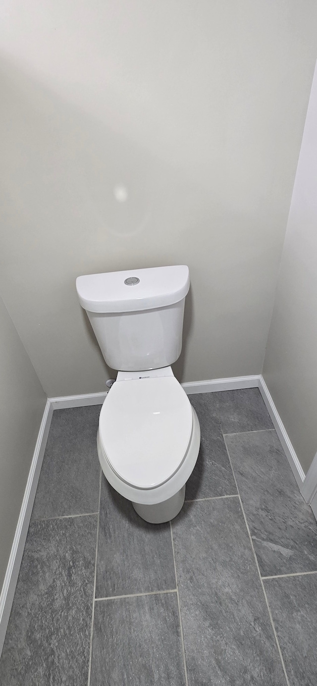 bathroom with baseboards and toilet