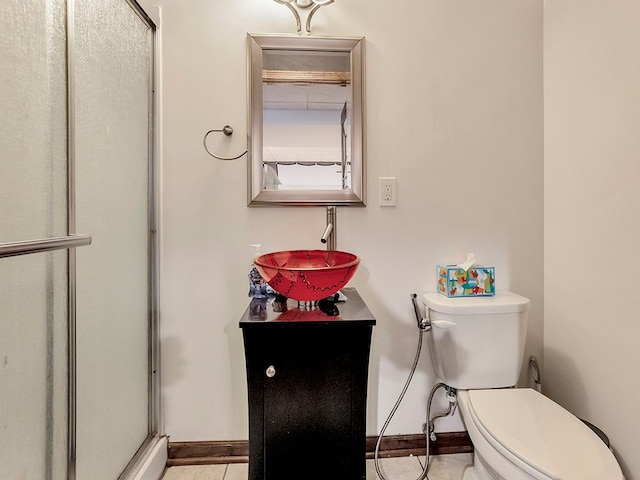 full bath featuring tile patterned floors, toilet, vanity, baseboards, and a stall shower