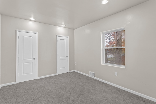 empty room with recessed lighting, carpet floors, visible vents, and baseboards
