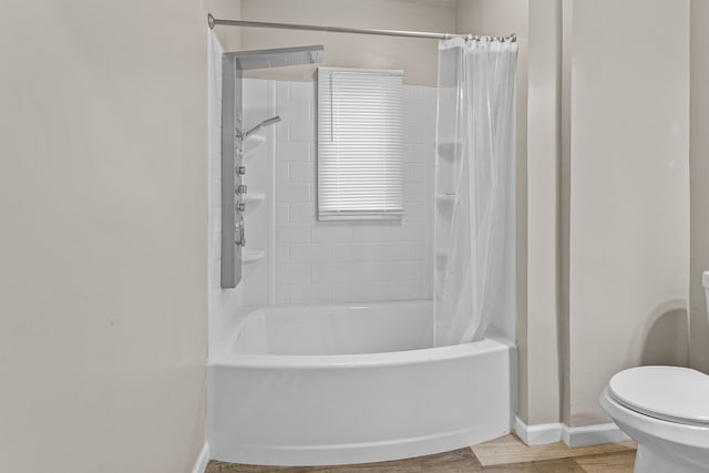 bathroom featuring shower / tub combo with curtain, toilet, baseboards, and wood finished floors