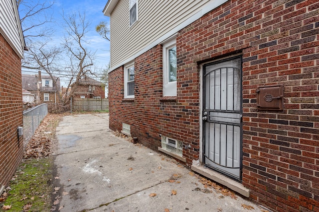 view of property exterior with brick siding and fence