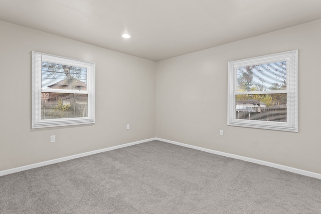 carpeted empty room featuring recessed lighting, plenty of natural light, and baseboards