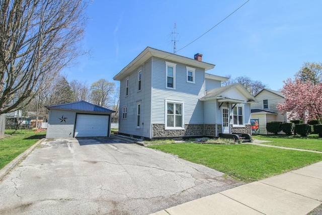 view of front of house with a chimney, aphalt driveway, an outdoor structure, a front yard, and a garage
