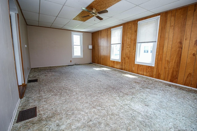 spare room with baseboards, a ceiling fan, and visible vents