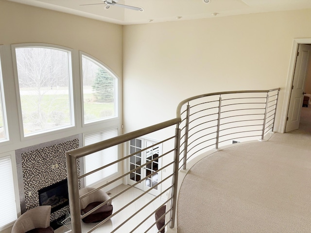 stairway featuring a fireplace, carpet, and a ceiling fan