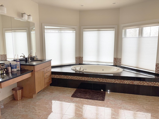 bathroom featuring a garden tub, tile patterned floors, and vanity