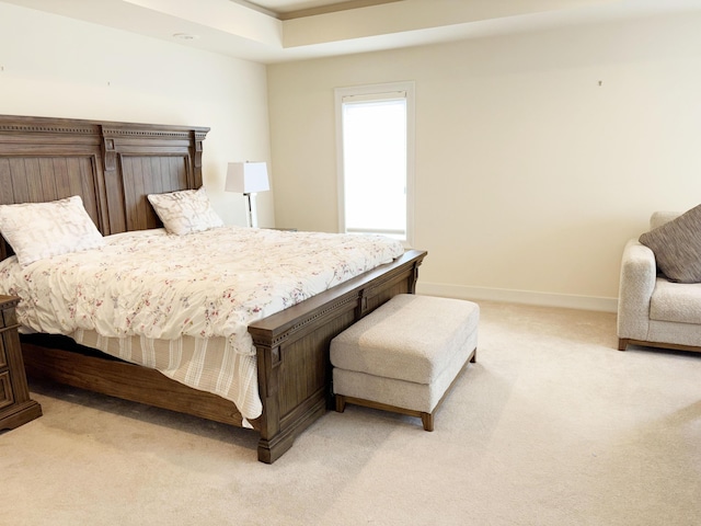 bedroom with baseboards and light colored carpet