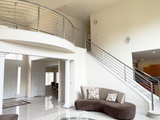 stairs featuring a high ceiling and decorative columns