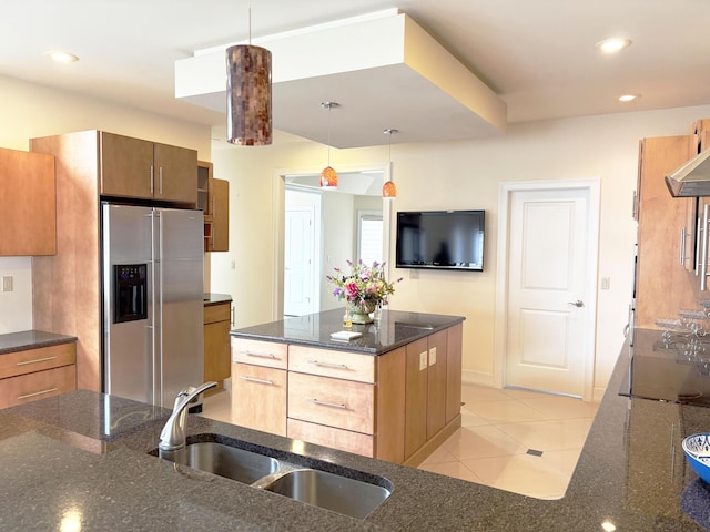 kitchen featuring a sink, dark stone countertops, recessed lighting, stainless steel fridge with ice dispenser, and decorative light fixtures
