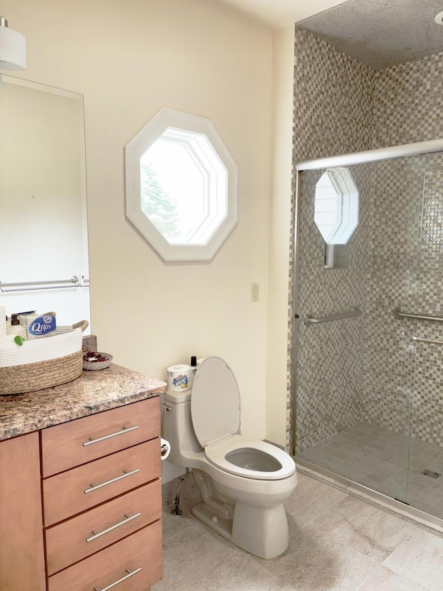 full bathroom featuring a shower stall, toilet, and vanity