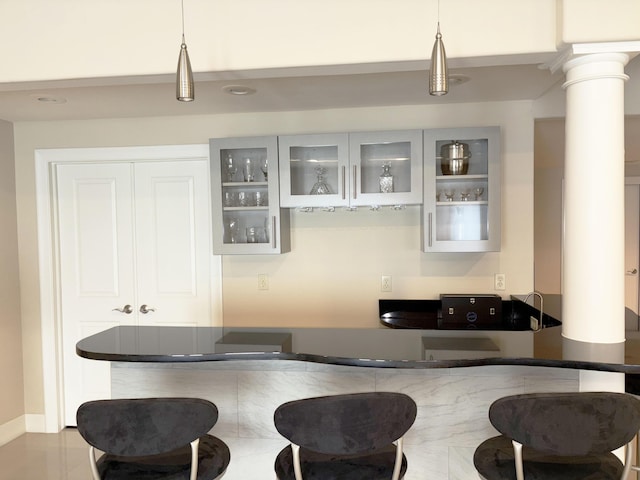 bar featuring ornate columns and hanging light fixtures