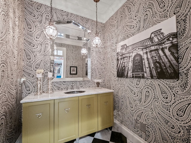 bathroom with wallpapered walls, baseboards, vanity, and a chandelier