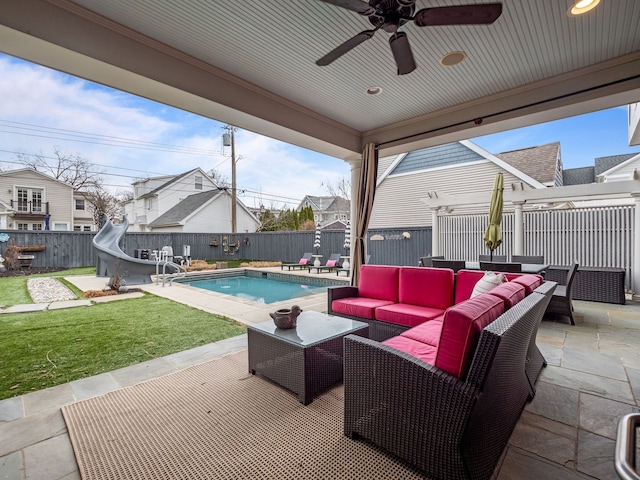 view of patio / terrace featuring an outdoor living space, ceiling fan, a fenced backyard, and a fenced in pool