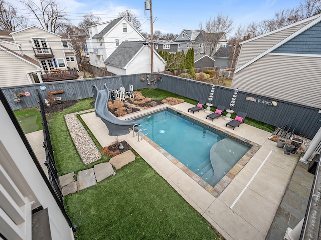 view of swimming pool featuring a water slide, a patio area, a residential view, and a fenced backyard
