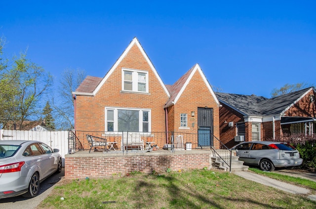 view of front of house featuring brick siding and fence