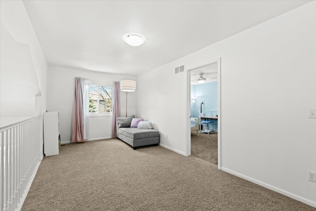 interior space with baseboards, visible vents, light carpet, and ceiling fan