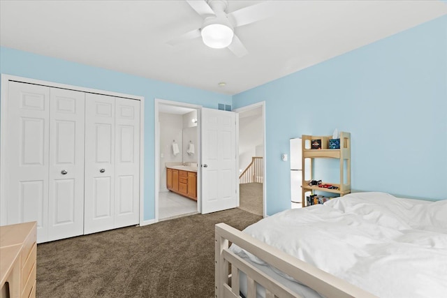 bedroom with ceiling fan, visible vents, a closet, connected bathroom, and dark carpet
