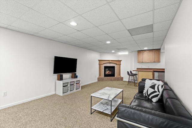 living room featuring a paneled ceiling, light colored carpet, baseboards, a glass covered fireplace, and recessed lighting