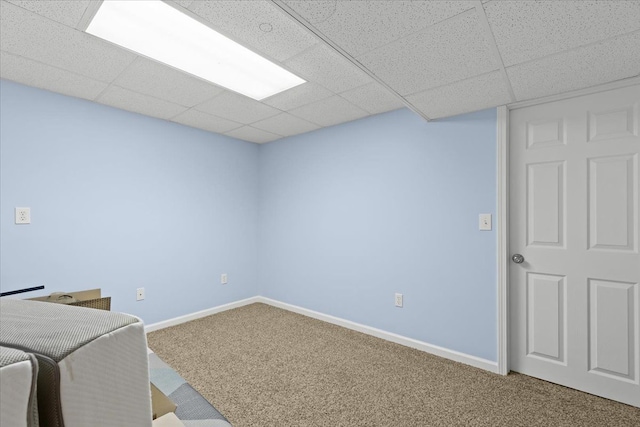 interior space with carpet floors, baseboards, and a drop ceiling