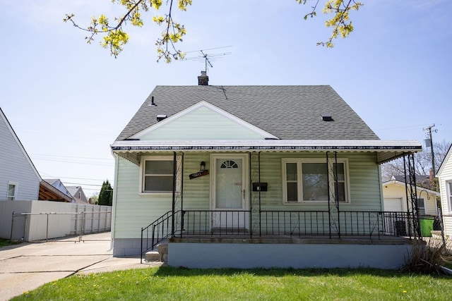 bungalow-style home featuring fence, a porch, and roof with shingles