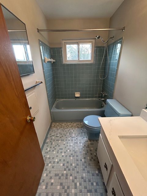 bathroom featuring vanity, shower / bathing tub combination, tile patterned floors, and toilet