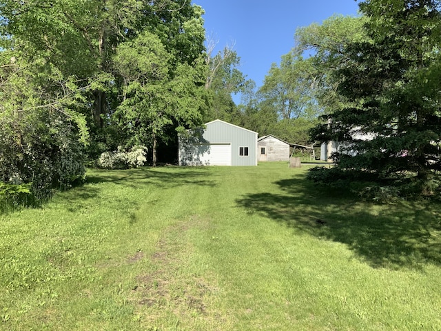 view of yard with an outdoor structure and a detached garage