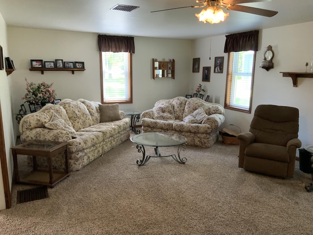 carpeted living area with ceiling fan, visible vents, and plenty of natural light