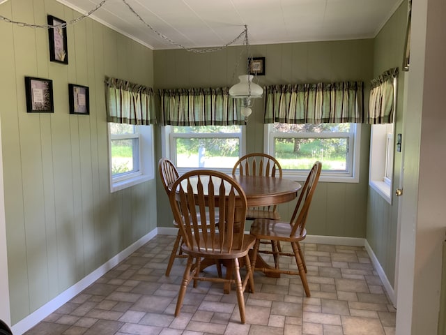 dining room featuring brick floor and baseboards