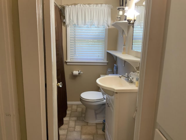 full bath featuring toilet, baseboards, stone finish flooring, a shower with shower curtain, and vanity