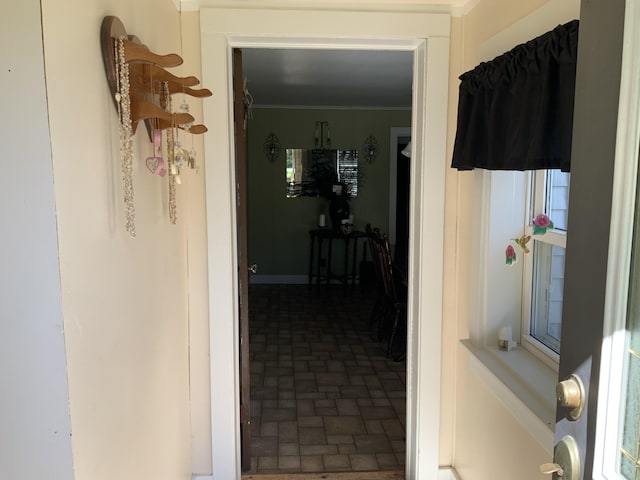 hallway with brick patterned floor and crown molding