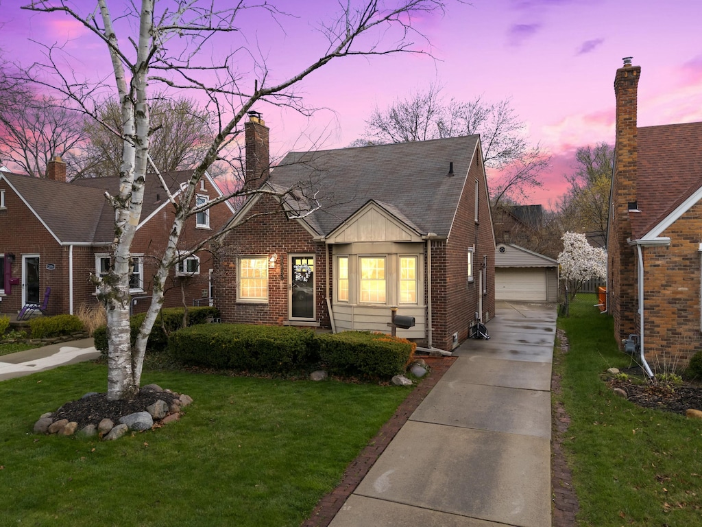 2048 Anita Ave, Grosse Pointe Woods, MI 48236 - view of front of home featuring an outdoor structure, a front yard, a garage, and brick siding