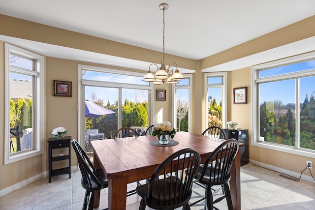 dining space featuring plenty of natural light, an inviting chandelier, and baseboards