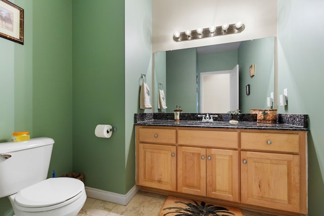 half bathroom featuring baseboards, marble finish floor, vanity, and toilet