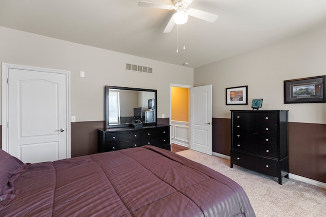 bedroom with carpet, visible vents, a ceiling fan, and wainscoting