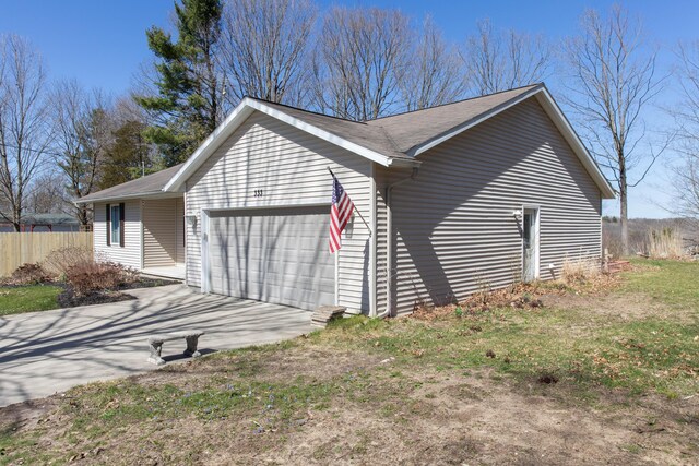 333 Quarterline St, Newaygo, MI 49337 - view of side of property with fence, driveway, and a garage
