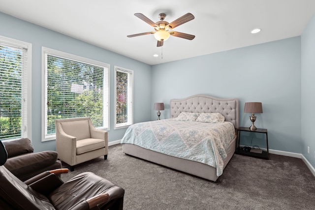 carpeted bedroom featuring baseboards, ceiling fan, and multiple windows