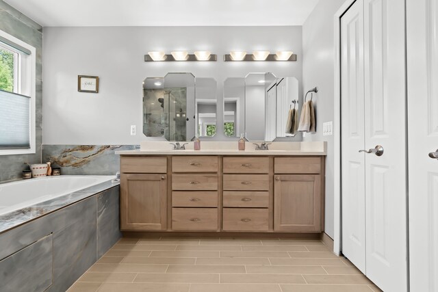 bathroom featuring a garden tub, a sink, double vanity, and a stall shower
