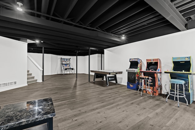 finished basement with stairs, wood finished floors, visible vents, and baseboards