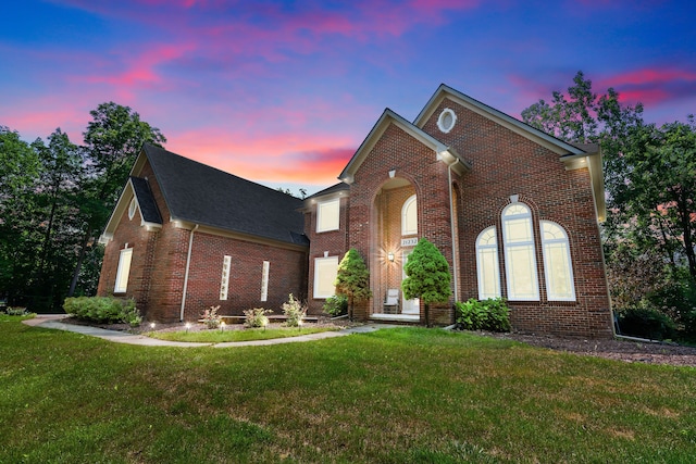 traditional-style house with brick siding and a front yard