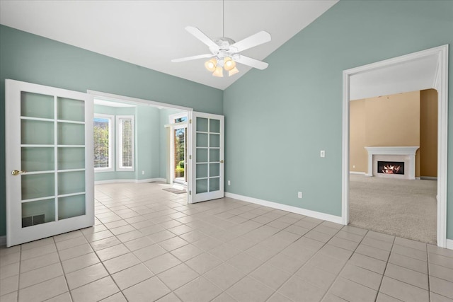 48491 Inveraray Rd, Canton, MI 48188 - empty room with light tile patterned floors, a ceiling fan, a lit fireplace, baseboards, and high vaulted ceiling
