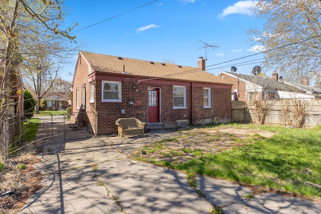 26488 Stollman Dr, Inkster, MI 48141 - rear view of house with roof with shingles, a gate, a chimney, fence, and brick siding
