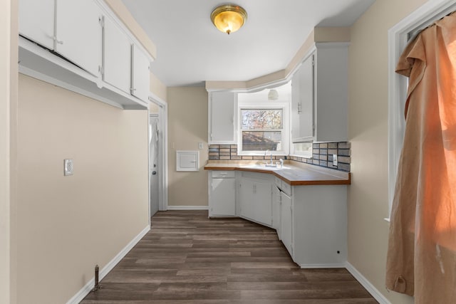 26488 Stollman Dr, Inkster, MI 48141 - kitchen with decorative backsplash, baseboards, dark wood-type flooring, and white cabinets