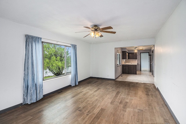 92 Brookfield Dr, Oxford, MI 48371 - unfurnished living room featuring a ceiling fan, light wood-type flooring, a chandelier, and baseboards