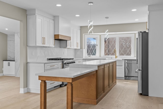 kitchen featuring white cabinets, light wood-type flooring, appliances with stainless steel finishes, and decorative backsplash